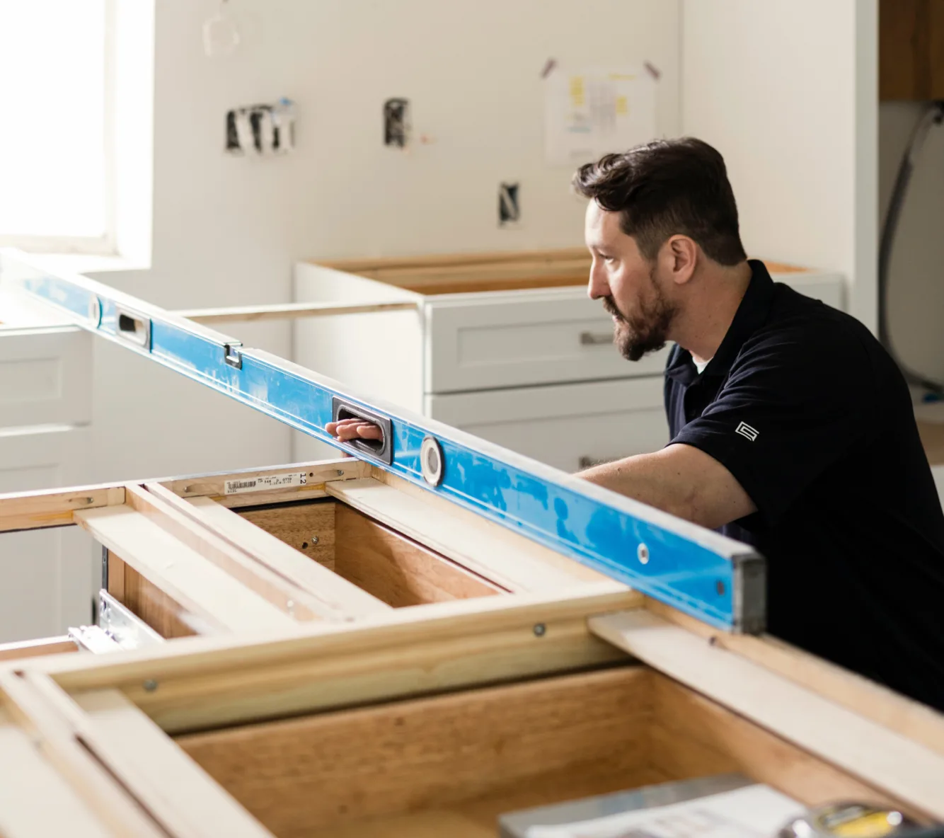 Installer fitting custom cabinets during a Scottsdale kitchen remodel