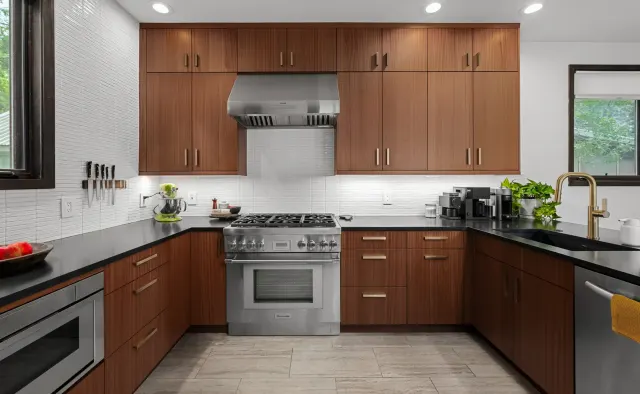 Annie Street Residence: Mid-century walnut flat-panel, U-shaped compact layout, black countertops, white backsplash, brushed-gold fixtures — view 3