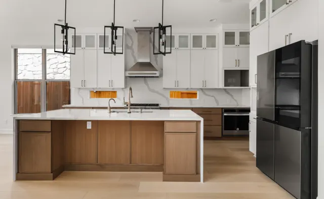 Black Gold Bend Residence: White uppers + rift-cut oak lowers/island, dramatic veined quartz counters and backsplash, glass-front uppers, black refrigerator, brushed-gold hardware — view 1