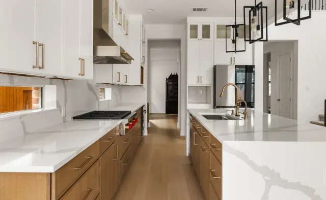 Black Gold Bend Residence: White uppers + rift-cut oak lowers/island, dramatic veined quartz counters and backsplash, glass-front uppers, black refrigerator, brushed-gold hardware — view 2