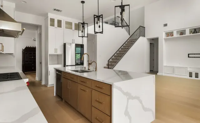 Black Gold Bend Residence: White uppers + rift-cut oak lowers/island, dramatic veined quartz counters and backsplash, glass-front uppers, black refrigerator, brushed-gold hardware — view 3