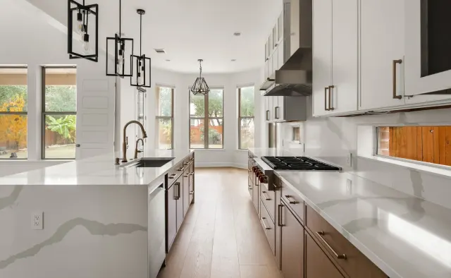 Black Gold Bend Residence: White uppers + rift-cut oak lowers/island, dramatic veined quartz counters and backsplash, glass-front uppers, black refrigerator, brushed-gold hardware — view 4