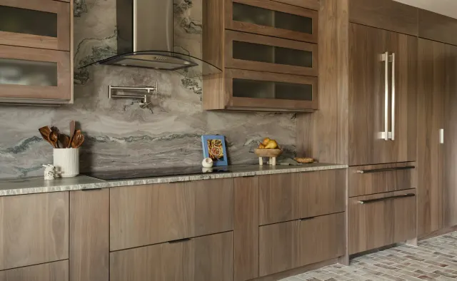 Burnside Circle Residence: Walnut flat-panel from Bellmont's semi-custom line, frameless construction, integrated refrigerator panels, frosted-glass uppers, deep drawer banks, pot filler — view 1