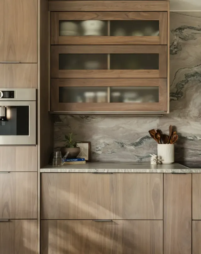 Burnside Circle Residence: Walnut flat-panel from Bellmont's semi-custom line, frameless construction, integrated refrigerator panels, frosted-glass uppers, deep drawer banks, pot filler — view 3