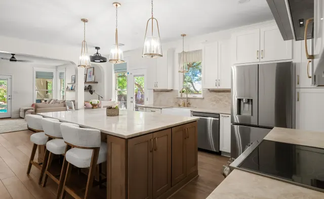 Falling Leaves Ct Residence: White perimeter + wood-stained island, large seating island, quartz counters, textured stone backsplash, open-concept — view 1