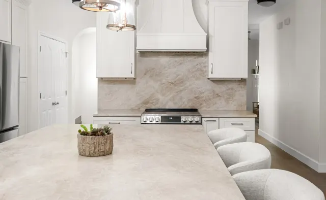 Falling Leaves Ct Residence: White perimeter + wood-stained island, large seating island, quartz counters, textured stone backsplash, open-concept — view 3