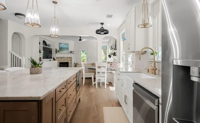 Falling Leaves Ct Residence: White perimeter + wood-stained island, large seating island, quartz counters, textured stone backsplash, open-concept — view 4