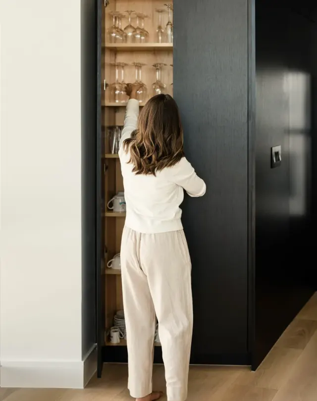 Rainey Street Residence: Matte-black full-custom cabinetry, floor-to-ceiling concealed appliances, black-and-white veined stone backsplash, light oak floors — view 4